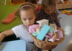 dziewczynka układa zabawki na pólkach
